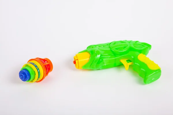 Toy gun with spinning top on white paper background — Stock Photo, Image