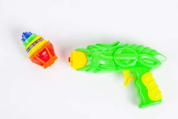 Toy gun with spinning top on white paper background — Stock Photo, Image