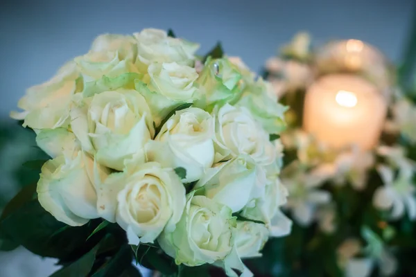 Свеча и свадебный букет белых роз — стоковое фото