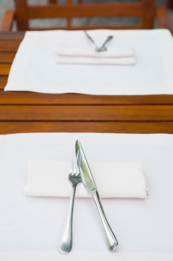 Çatal, bıçak, tabak ve peçeteli masa ayarları.