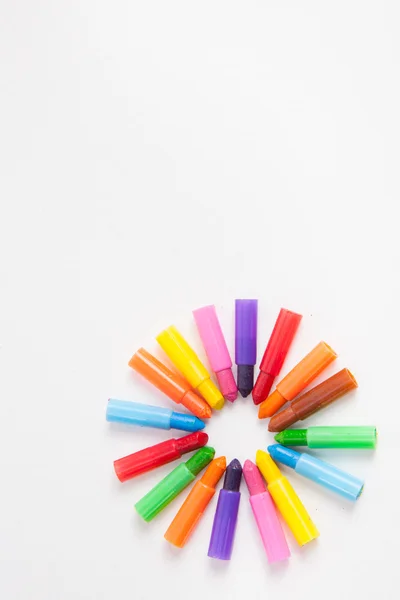 Lápis multicoloridos sobre um fundo de papel branco . — Fotografia de Stock