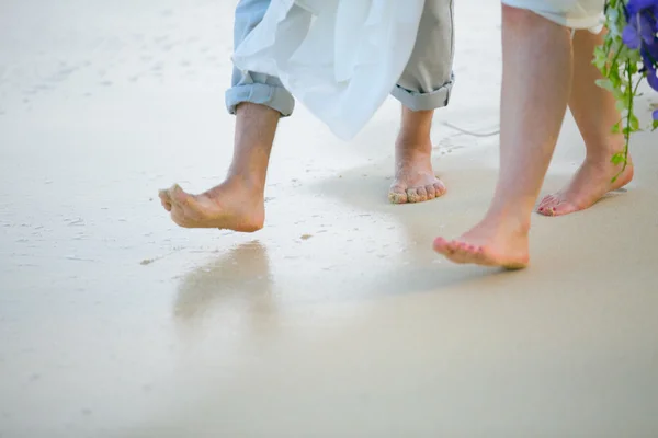 Os pés da noiva e do noivo brincando na praia — Fotografia de Stock