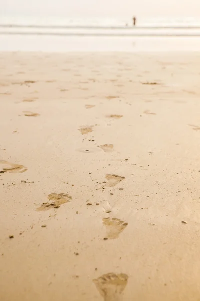 Ślady na plaży w zachód słońca — Zdjęcie stockowe