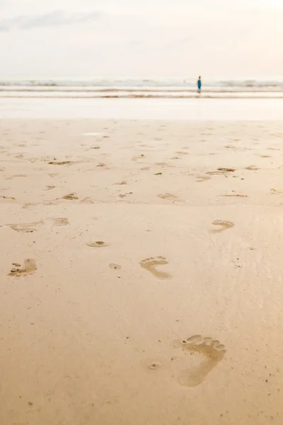 Empreintes de pas sur la plage au coucher du soleil — Photo