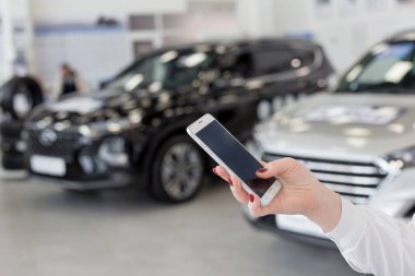 Kadın satıcı galeride cep telefonu kullanıyor. Modern çalışma süreci. Gelişmiş bilgisayar teknolojisi.