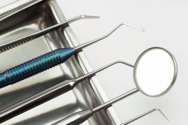 Tıbbi tepside farklı diş aletleri var. Beyaz arkaplanda izole.