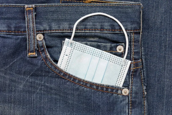 保護面マスクジーンズのサイドポケットに横たわっている Covid 19コロナウイルスパンデミック後の新しいライフスタイルのコンセプト — ストック写真