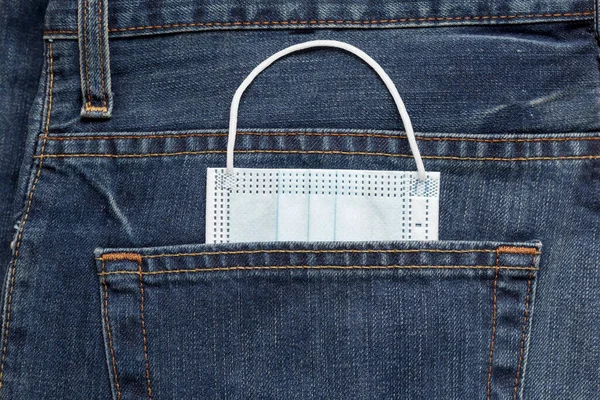 保護面マスクジーンズのバックポケットに横たわっている。新しいライフスタイルのコンセプト. — ストック写真