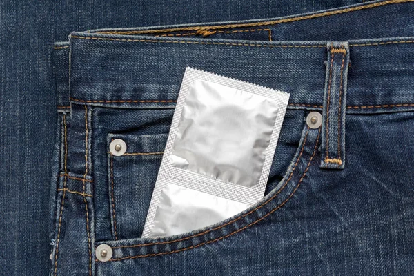 Silver pack condoms are lying in side pocket of jeans. Concept safely sex, prevention from aids. — Stock Photo, Image