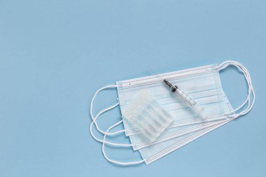 Koruyucu yüz maskeleri, aşılı ampuller ve aşı için harcanabilir şırınga. Koronavirüs enfeksiyonunun tedavisi.