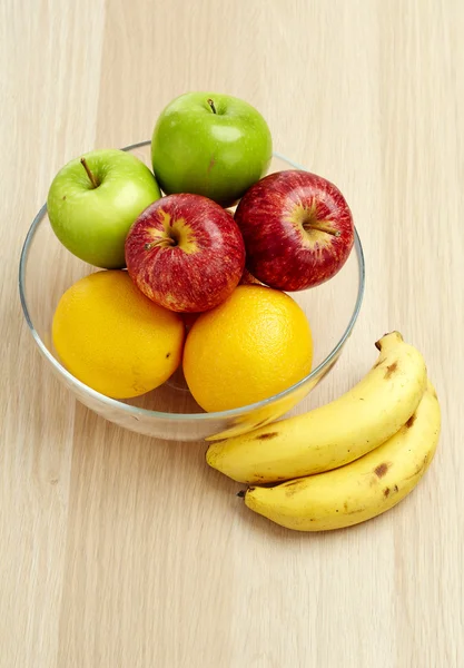 Glazen kom met fruit voor dieet op de houten tafel Stockfoto