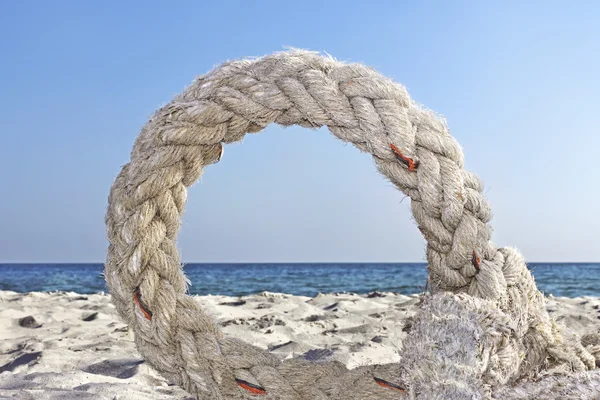 Кольцо старой веревки на берегу моря — стоковое фото