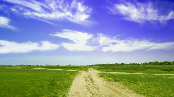 草原间的乡村沙地路 草地上方的美丽云彩 艺术结构型 — 图库照片
