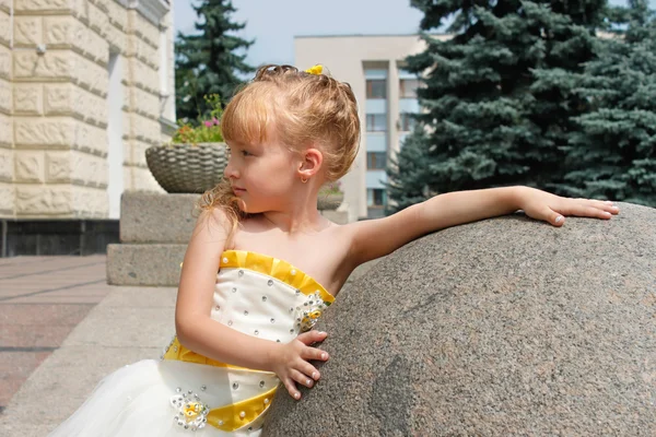 Small girl near a marble ball in a summer day — Stock Photo, Image