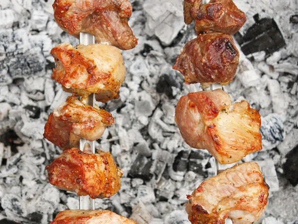 Shish kebab sur brochettes métalliques sur charbon de bois avec des cendres — Photo