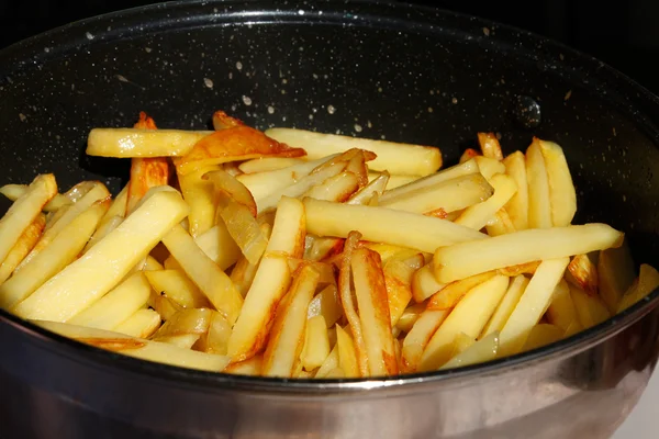 Жареные картофельные чипсы в металлической сковороде — стоковое фото