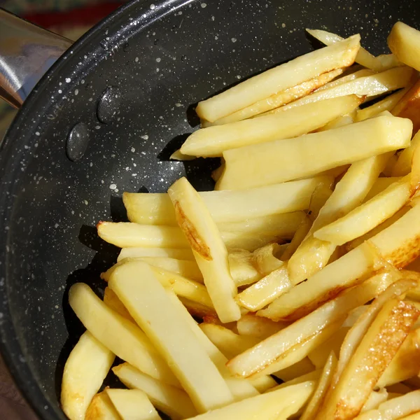 Жареные картофельные чипсы в сковороде — стоковое фото