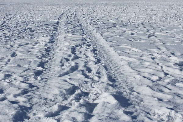 車輪のトラックおよび雪の上の人間の足跡 — ストック写真