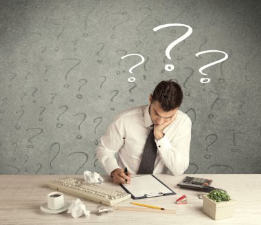 İş adamı soru işaretiyle masada.