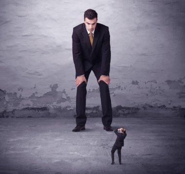 Kızgın büyük müdür küçük iş adamına bakıyor.