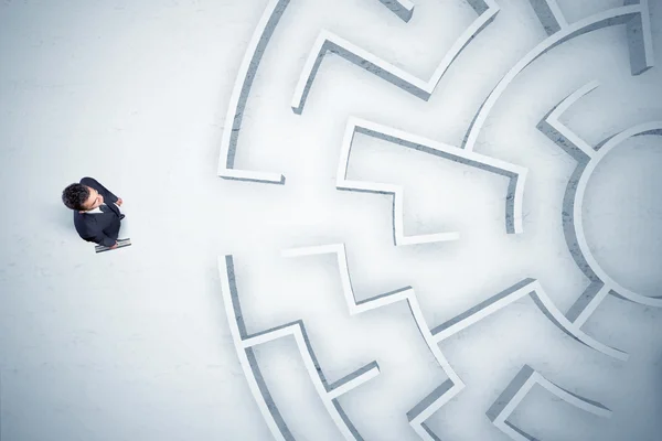 Hombre de negocios mirando laberinto circular sin dónde ir — Foto de Stock