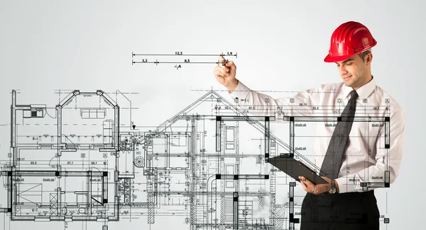 Genç bir mimar ev planı çiziyor.