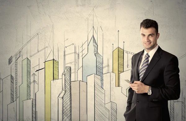 Businessman standing with drawn cityscape — Stock Photo, Image