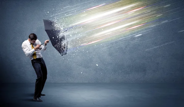 Business man defending light beams with umbrella concept — Stock Photo, Image