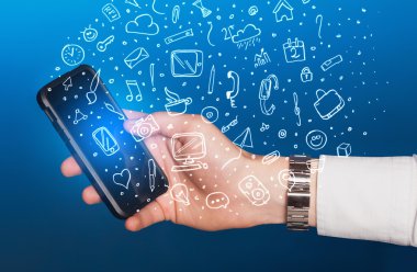 Elle çizilmiş medya simgeleri ve sembolleri ile akıllı telefonu tutmak