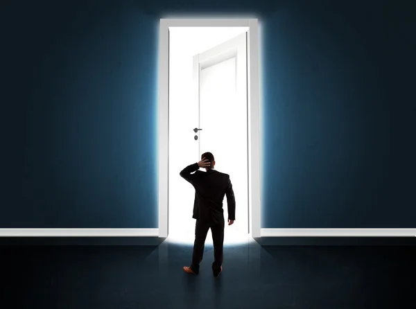 Geschäftsmann blickt auf große helle geöffnete Tür — Stockfoto