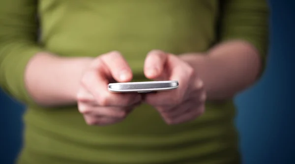 Jovem mulher segurando smarthphone na mão — Fotografia de Stock