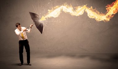 İş adamı kendini bir umbrell ile bir yangın oka savunmak