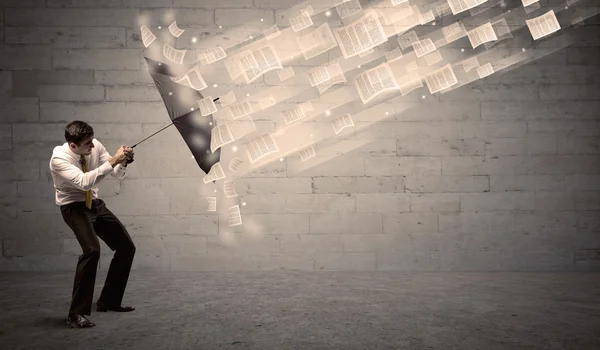 Üzletember esernyő papírok szél ellen védi — Stock Fotó