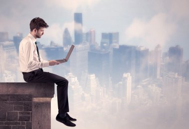 Yüksek bir binanın tepesinde oturan satıcı.