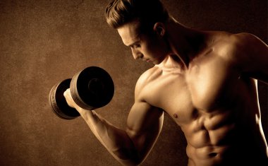 Kas formundaki vücut geliştirici sporcu ağırlık kaldırıyor 