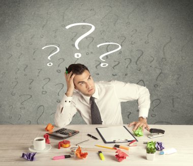 İş adamı soru işaretiyle masada.