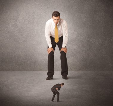 Büyük iş adamı küçük işçilere bakıyor.