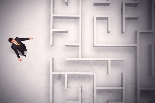 Förvirrad affärsman står vid en labyrint vägg — Stockfoto