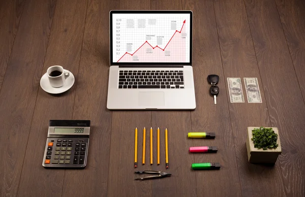 Mesa de computador com laptop e gráfico de seta vermelha na tela — Fotografia de Stock