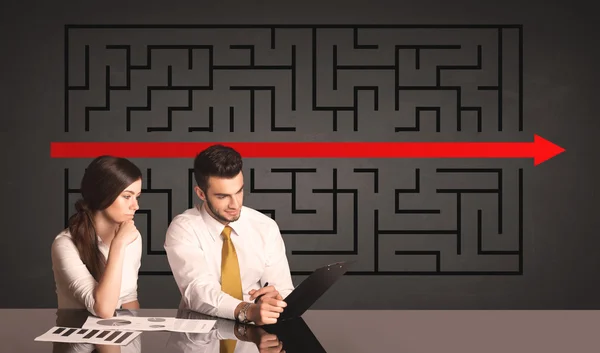 Business couple with a solved puzzle in background — Stock Photo, Image