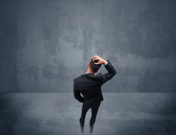 Businessman standing in front of urban wall — Stock Photo, Image