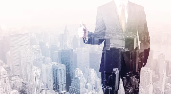 İş adamı çatıda duruyor ve arka planda şehir var.