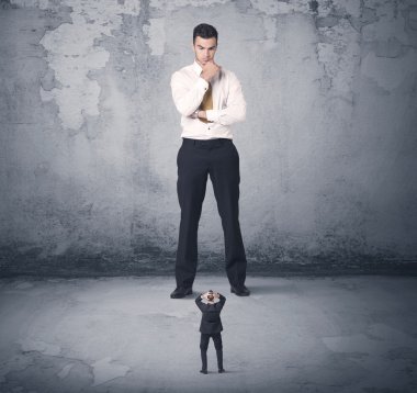 Büyük işletme zorbası küçük iş arkadaşına bakıyor.