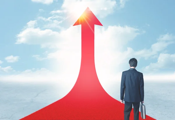 Empresário em pé sobre uma seta vermelha — Fotografia de Stock