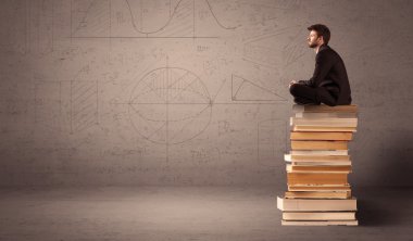 Kitaplar üzerinde oturan işadamı