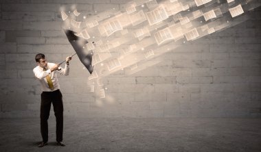 İş adamı ile şemsiye kağıtları rüzgara karşı koruma