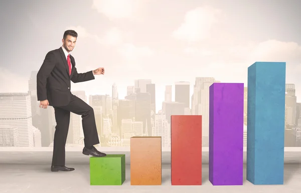 Pessoa de negócios subindo no conceito de pilares gráficos coloridos — Fotografia de Stock