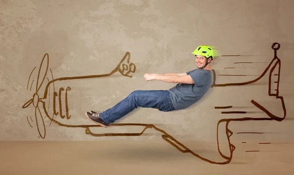 Funny pilot driving a hand drawn airplane on the wall — Stock Photo, Image