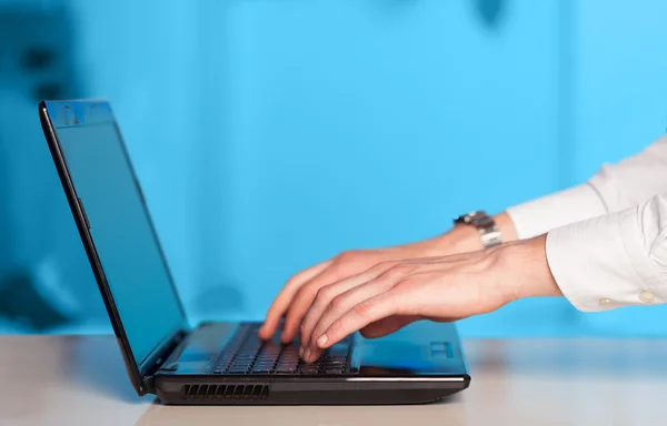 Empresário pressionando computador portátil moderno em backgrou colorido — Fotografia de Stock