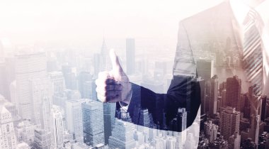 İş adamı çatıda duruyor ve arka planda şehir var.